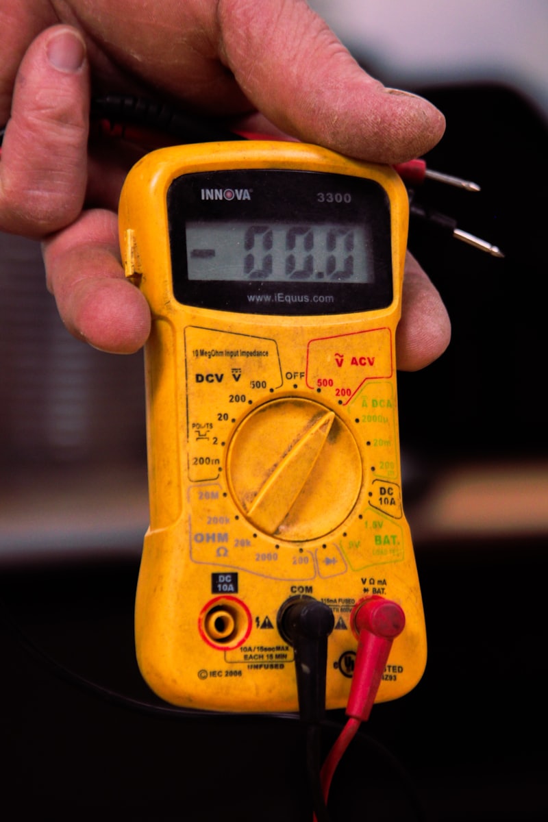 Technician using a multimeter to test electrical system